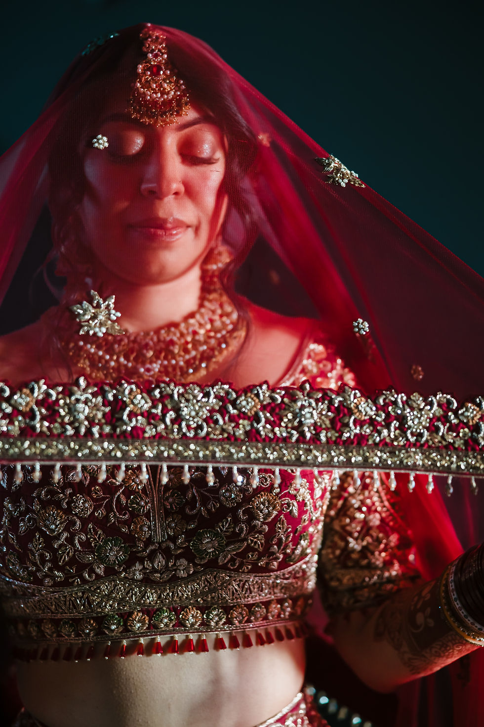 Close-up of Indian bride in red lehenga and embroidered dupatta during bridal portraits at Dreams Bahia Mita