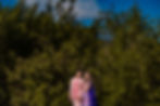 Indian couple in colorful outfits standing against lush greenery during their pre-wedding photo shoot at Hilton Cancun.