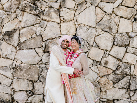 Indian bride and groom in pastel traditional wedding attire smiling after their Hindu ceremony in Mexico—capturing joyful moments of a destination Indian wedding