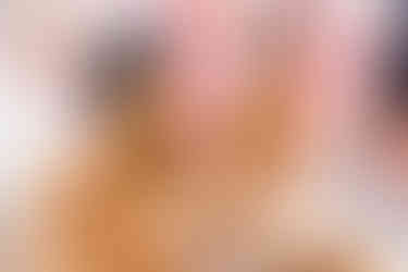 Bride and groom laughing together during their Haldi ceremony at Garza Blanca Cancun, covered in golden turmeric paste with vibrant floral decor in the background.