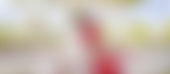 Indian bride and groom seated under a white floral mandap in Mexico, sharing a joyful moment surrounded by palm trees and tropical blooms during their destination wedding ceremony.