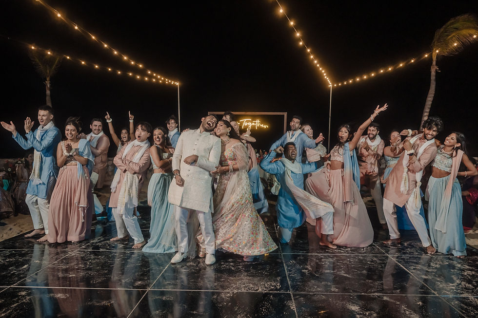 Indian wedding Sangeet night with bride, groom, and guests dancing under string lights—colorful pre-wedding celebration full of music and joy in Mexico