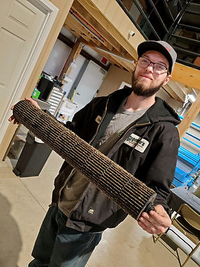 HVAC Technician Pulls Dirty Furnace Filter During Furnace Maintenance in Tiffin, Ohio