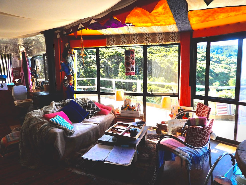 Colourful lounge with large sliding windows viewing to nature, Soul Thing retreat for sale New Zealand