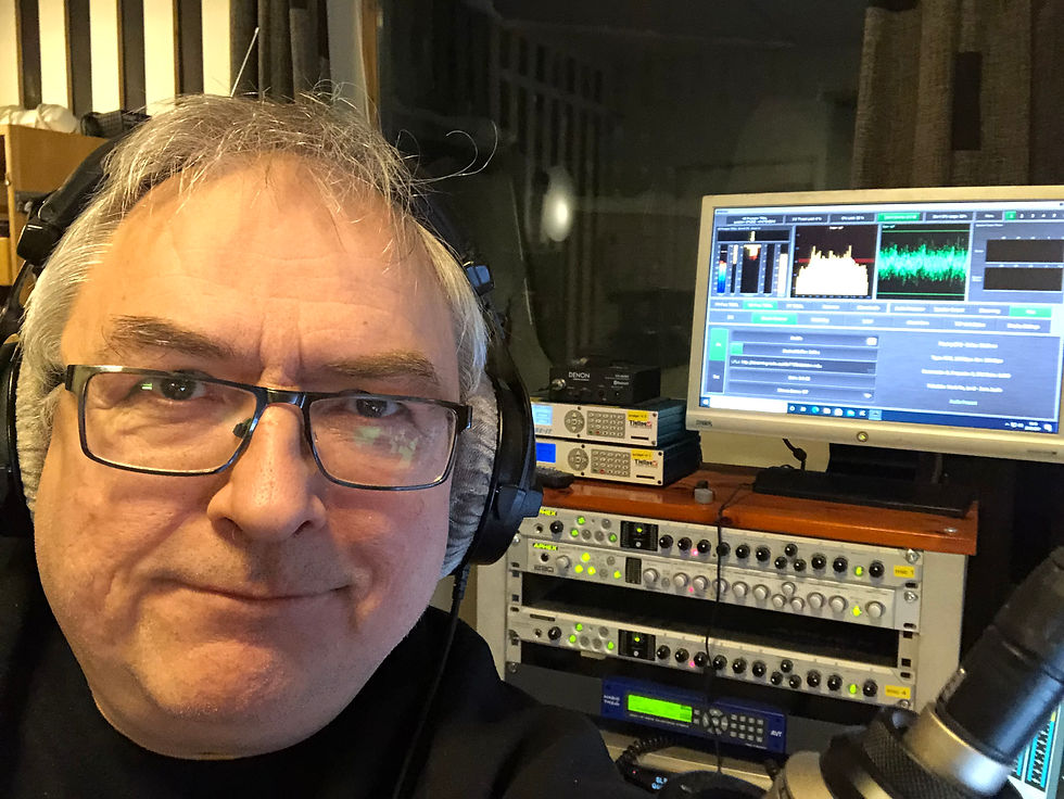 Mann med briller og øretelefoner i radiostudio.