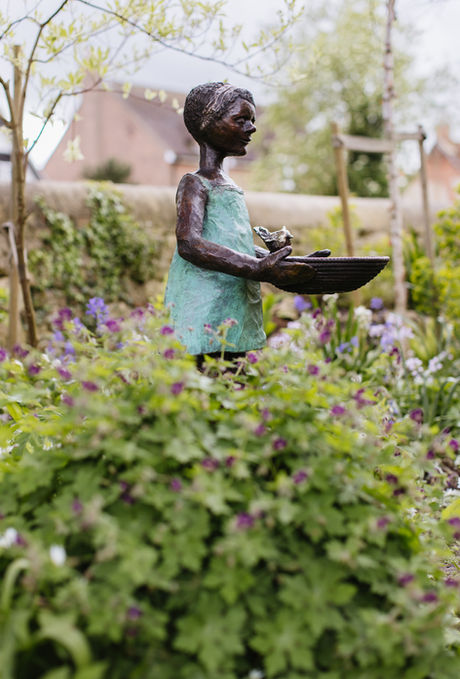 bronze girl bird bath garden sculpture. "Ava" draws inspiration from the Latin association with 'bird,' symbolising freedom and connection to nature, 'Ava' resonates with a sense of vitality, desire, and harmony with the natural world.
