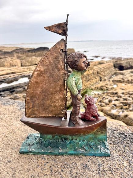 Bronze sculpture of a boy and a fox in a boat