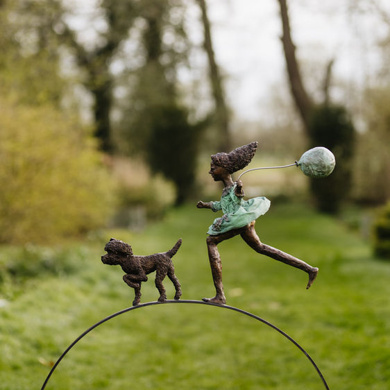 girl with balloon and dog running sculpture 