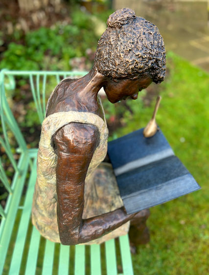 bronze girl reading with bird 