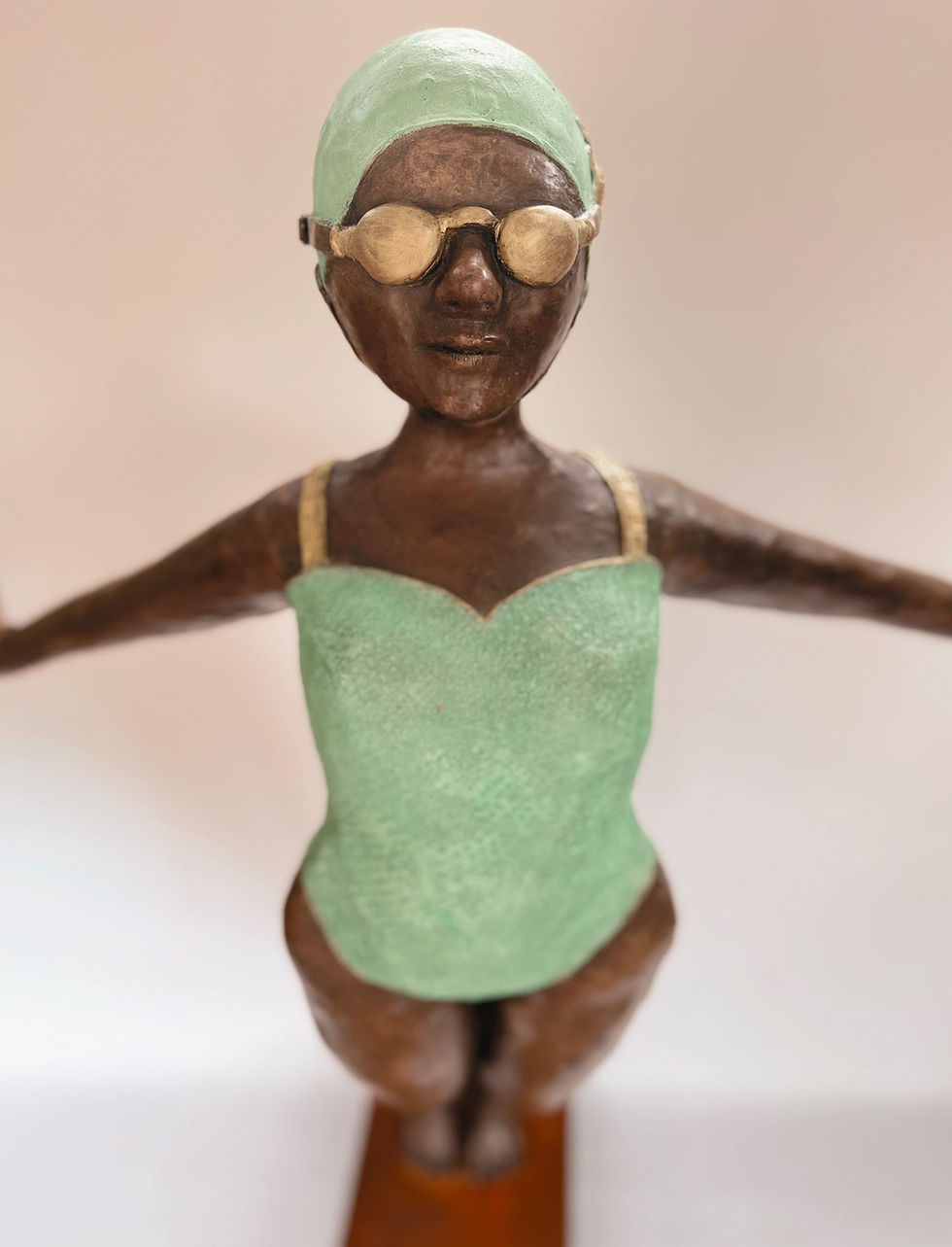 Thumbnail: Close-up of bronze swimmer sculpture wearing green cap and goggles