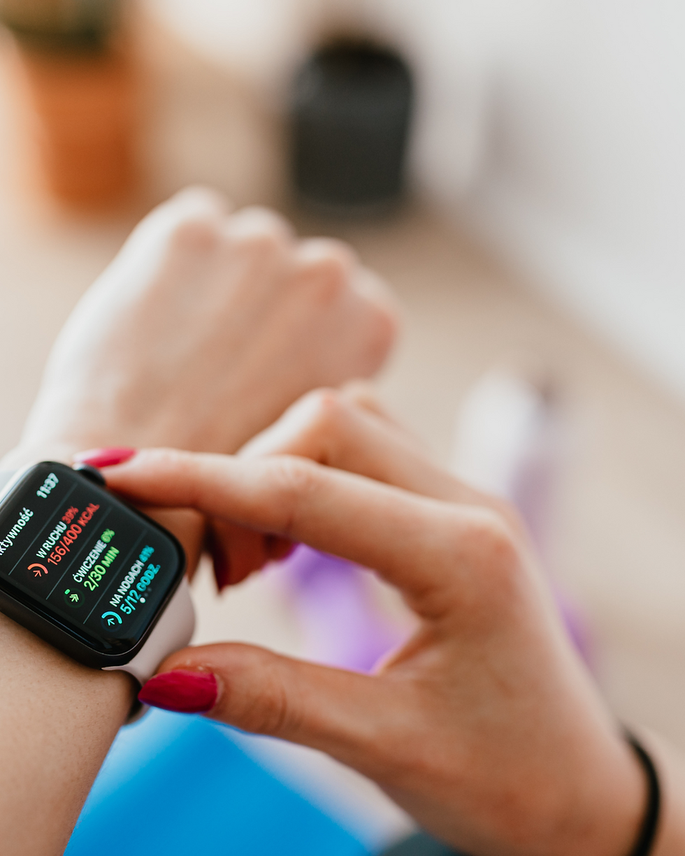 person with painted nails adjusting their smart watch on their wrist