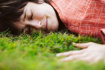Woman lying in soft grass smiling