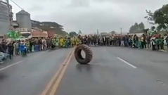 VÍDEO: BOLSONARISTAS DELIRANTES CANTAM HINO NACIONAL PARA UM PNEU DURANTE BLOQUEIO DE RODOVIA