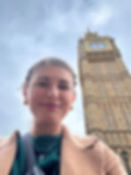 A woman with her hair pulled back smiles at the camera for a selfie. Behind her is London's famous clock tower, Big Ben.