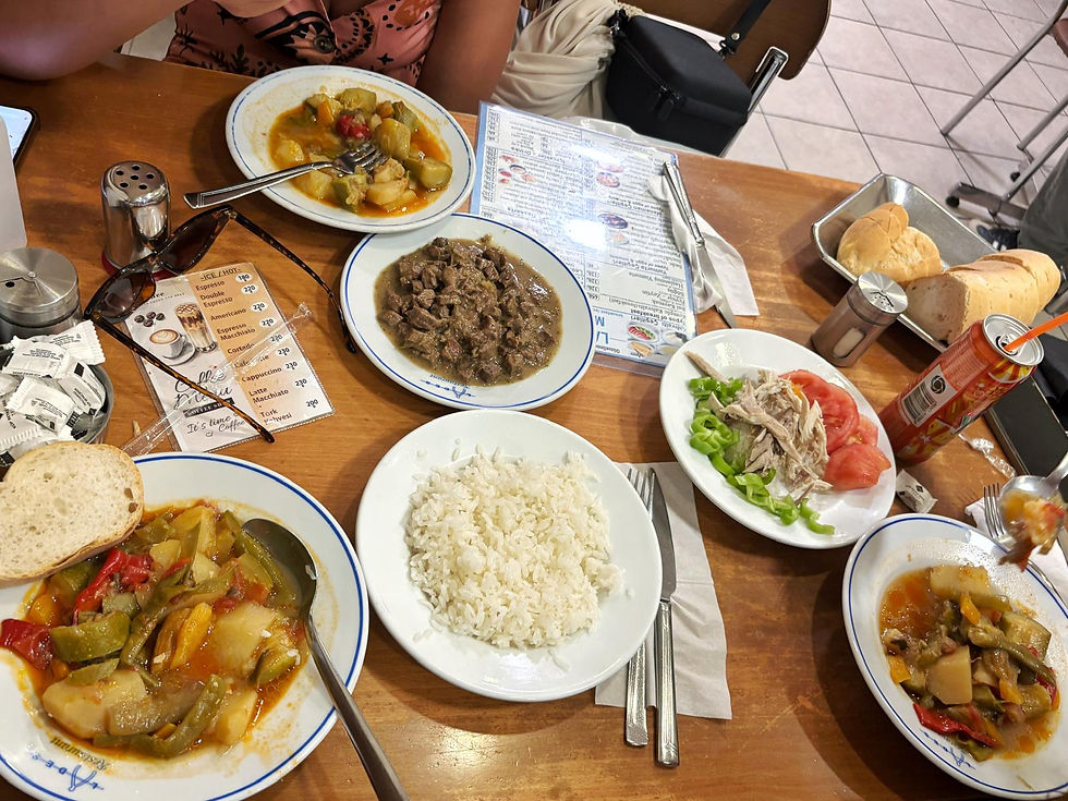 Turkish-style meal on a restaurant table: rice, stews, salad, bread, soda, and a coffee menu beside diners.
