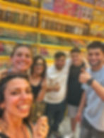 Group selfie of five smiling friends in a colorful spice shop, with jars of spices and a Misk Spice sign behind them.