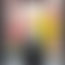 A suitcase stands by a large window with blossoming pink and yellow flowers outside. Bright, serene travel scene.