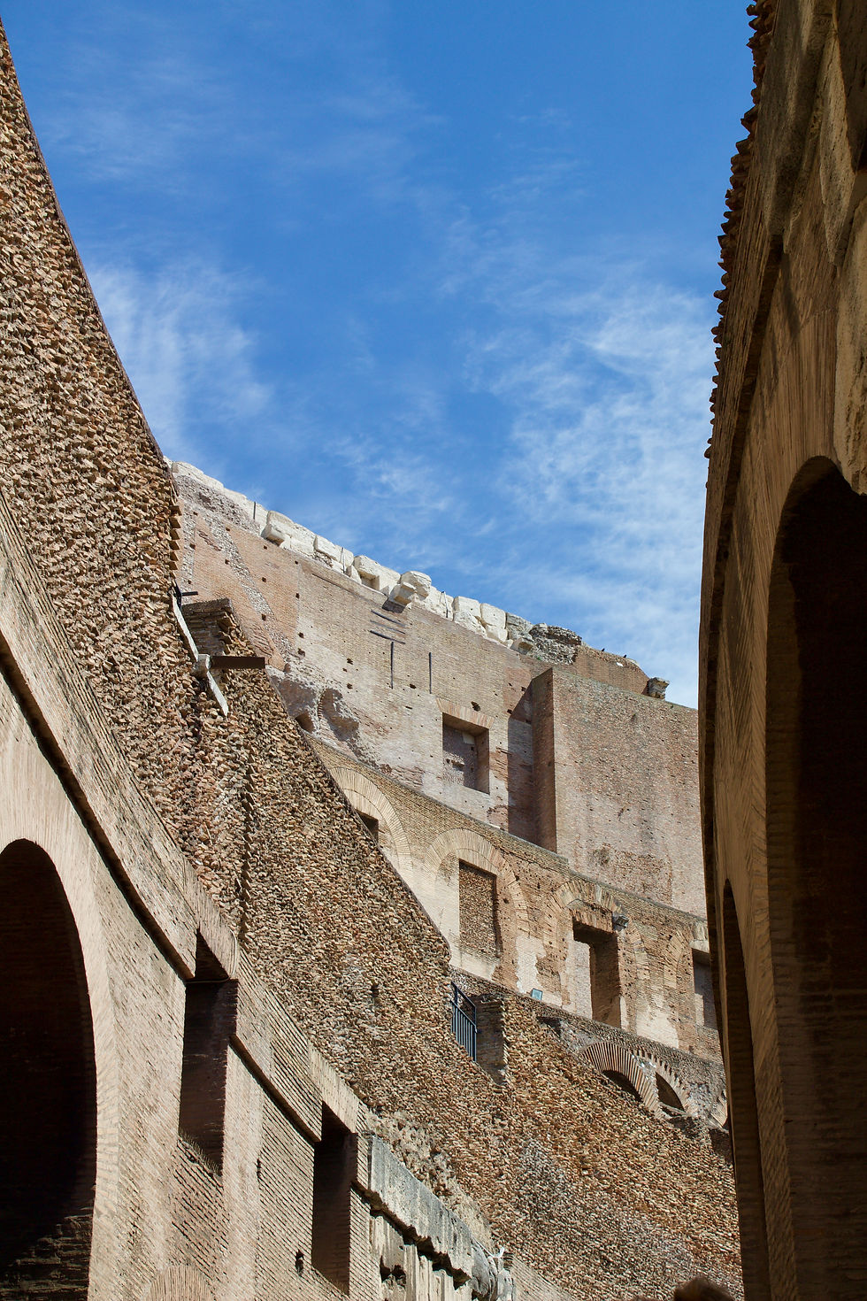 A view of the stone arches and interior curvature of the Roman Colosseum.