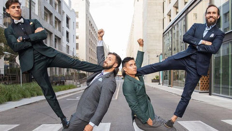4 men doing standing circus acrobatics in suits