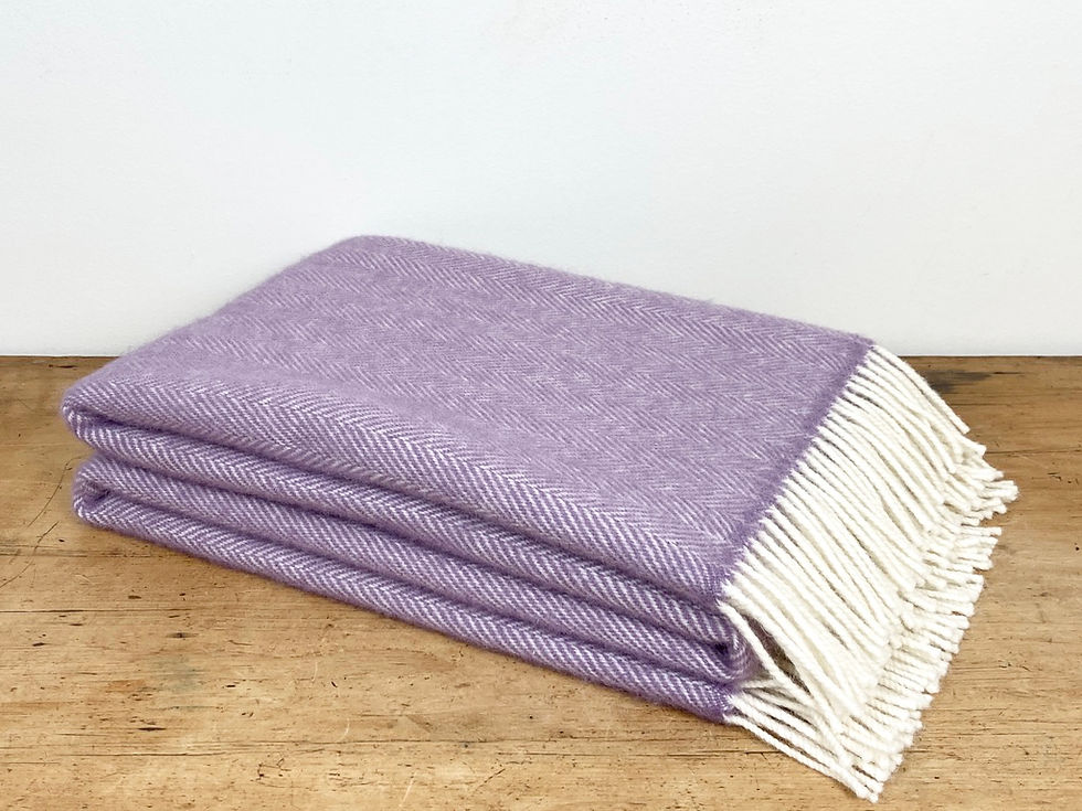 Thumbnail: Richmond Soft Mulberry throw, elegantly folded at an angle on a sideboard, displaying its soft ecru tassels and herringbone weave. Made from 100% British wool woven as worsted yarn for ultimate softness.