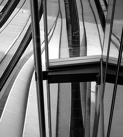 Black and white image of architecture building and roof of train station