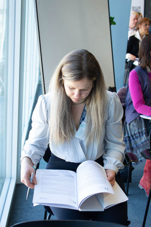 Woman reading Davitt Jones Bould webinar notes booklet