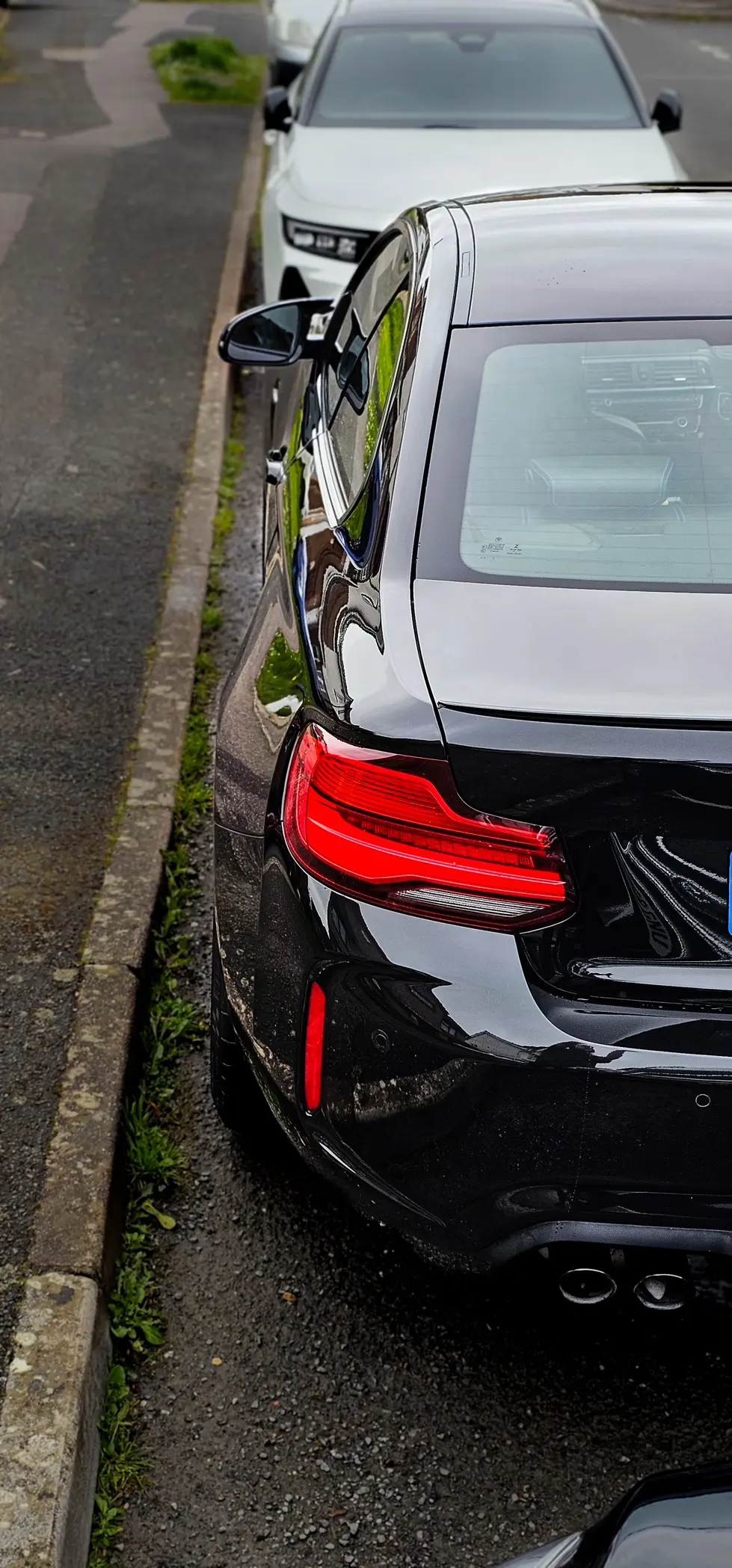 a black car is parked on the side of the road