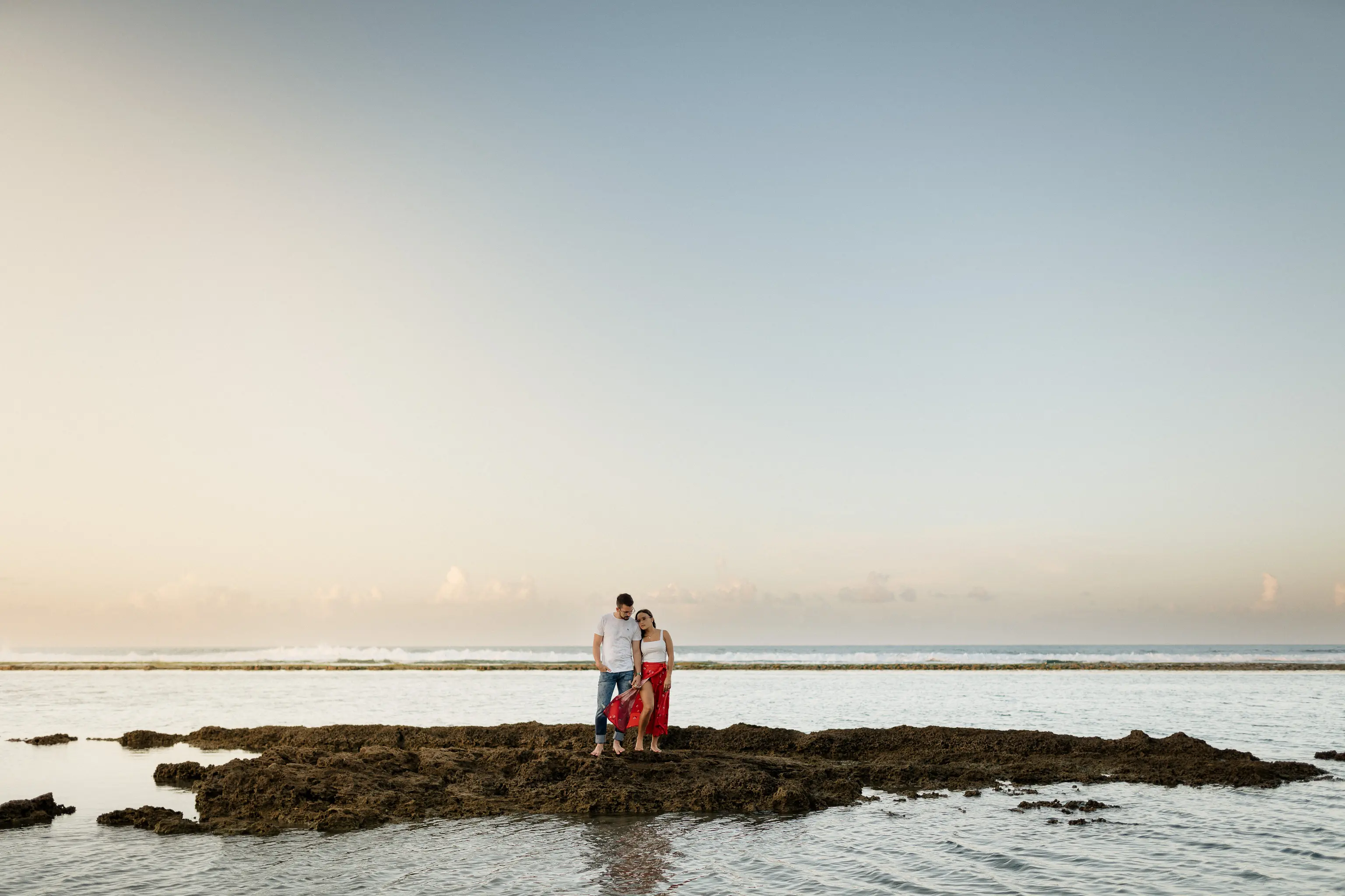 Couple holding hands at the beach at sunset posing for love story photo shoot in Puerto Rico