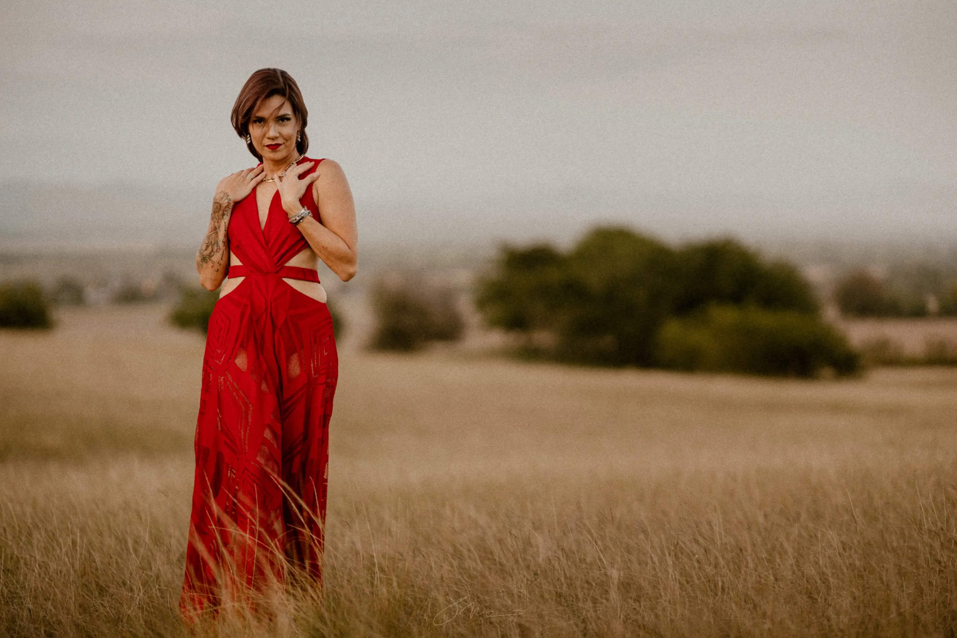 beautiful woman with tattoos on a red dress posing at the valley in Lajas Puerto Rico modeling