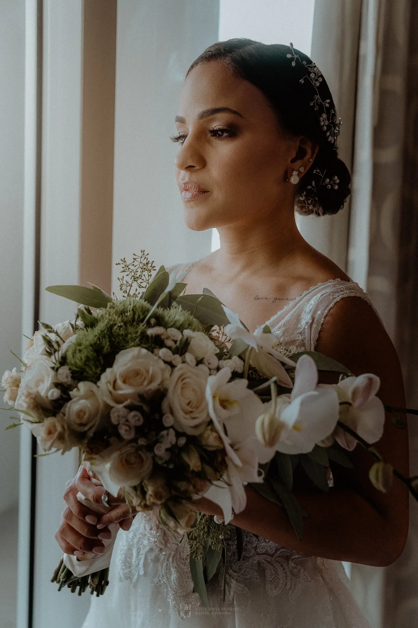 bride posing at the window with natural light and bouquet