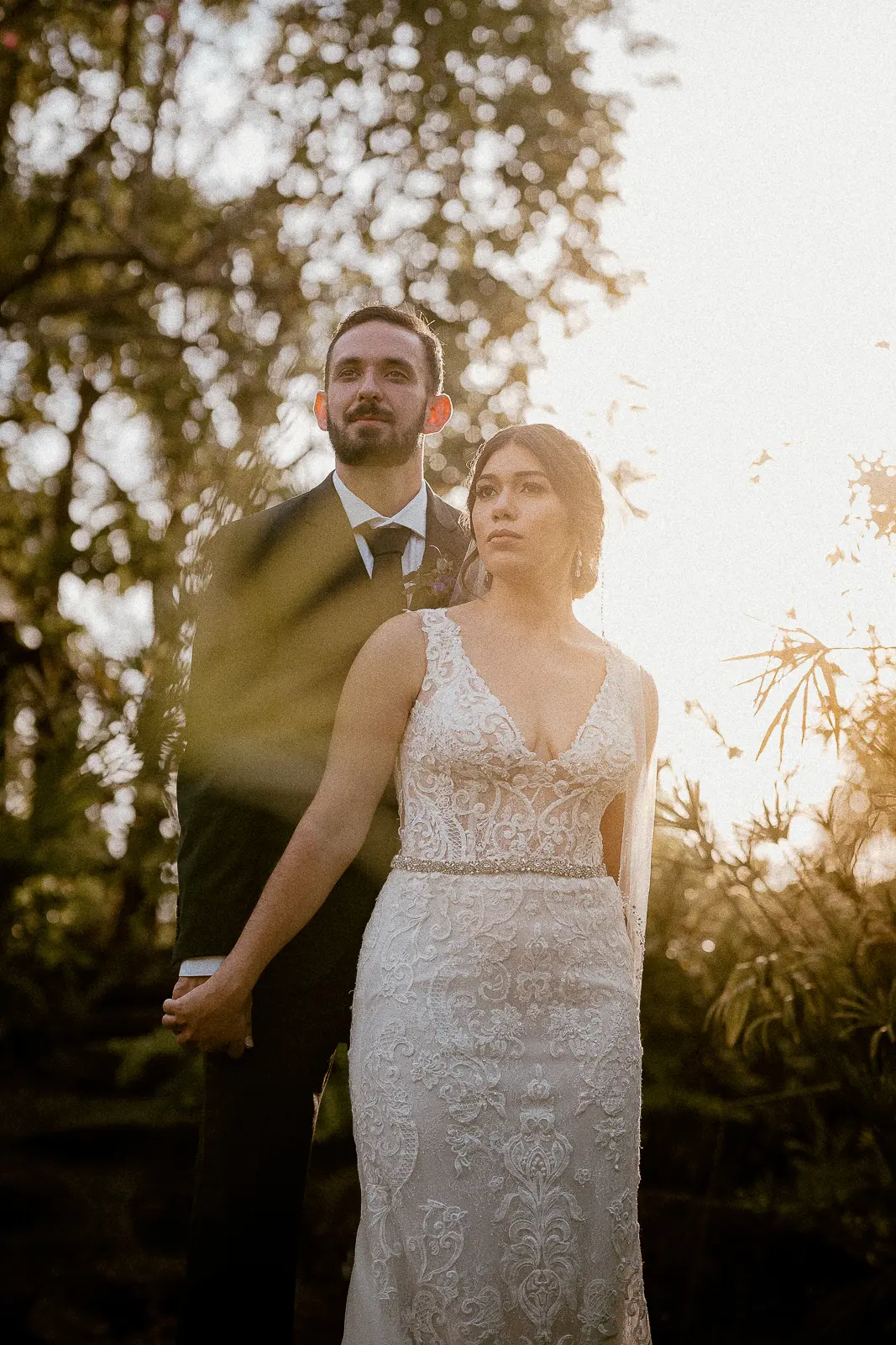 bride and groom posing for wedding photos at sunset