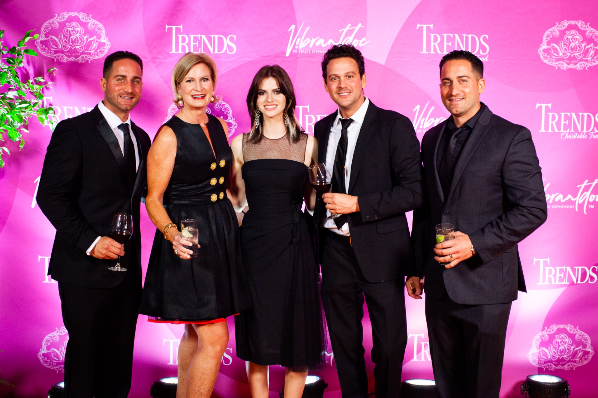 Guests in front of the pink Trends Charitable Fund backdrop