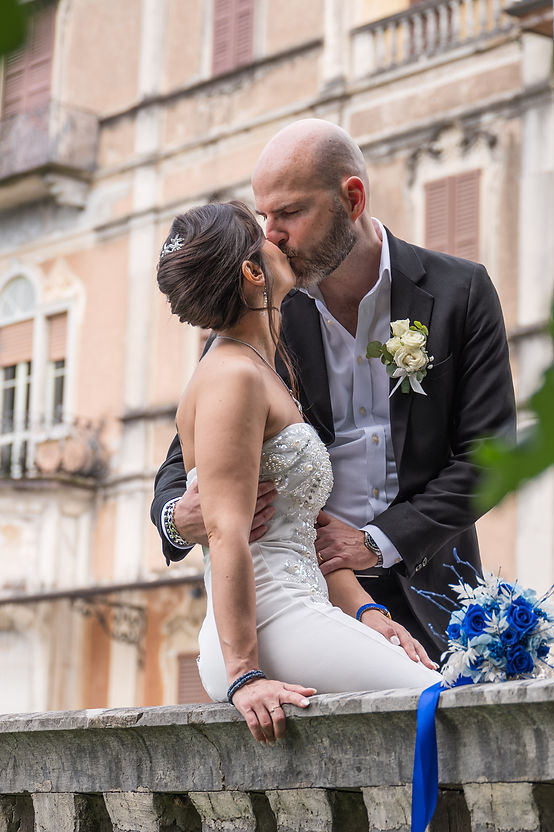 Bacio degli sposi sulla balaustra di Villa Cagnola, dettaglio del bouquet con rose blu a Gazzada