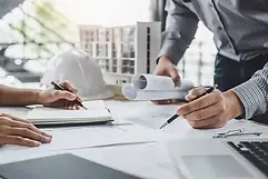 Problemas-na-gestão-de-obra-profissionais-trabalhando-sobre-a-mesa-com-projetos-de-constru