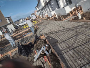 Pouring concrete on a driveway in an apartment complex.