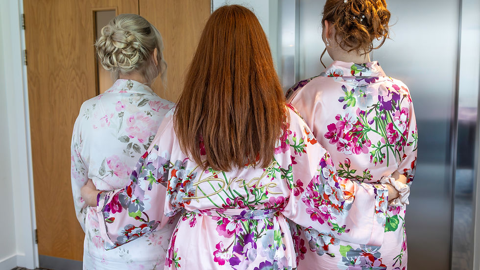 Zara and her bridesmaids in floral robes from behind