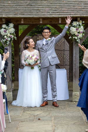 grooms waves to guests at wedding