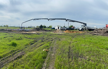 concrete pumping work site in grass field