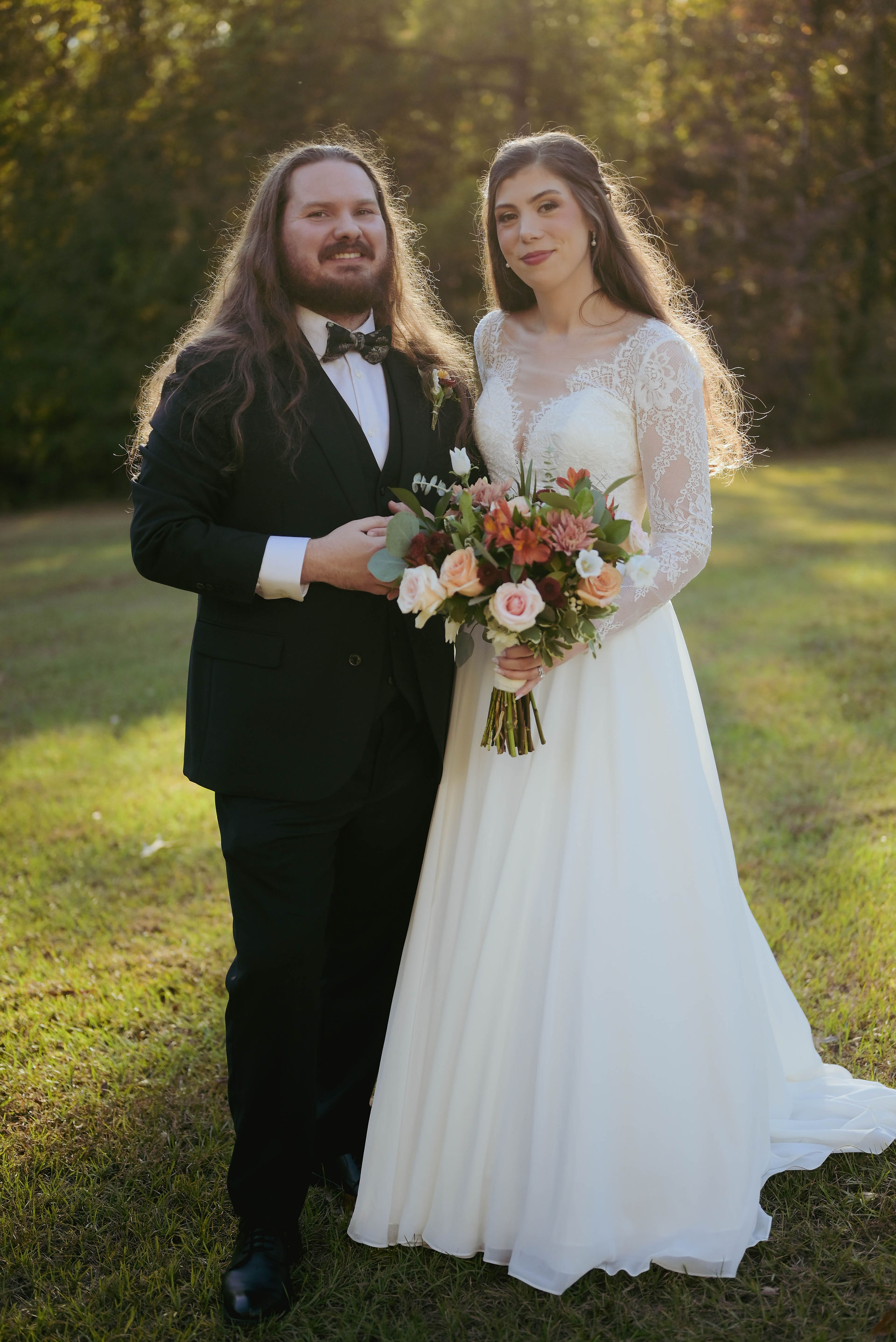 Bride and groom stand together in a field (Photo by Joel and Mo Photos)