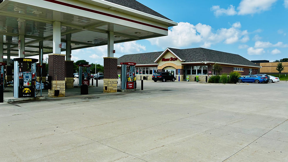 Exterior of gas station with business sign in red lettering that says Kwik Star and covered awning over gas pumps