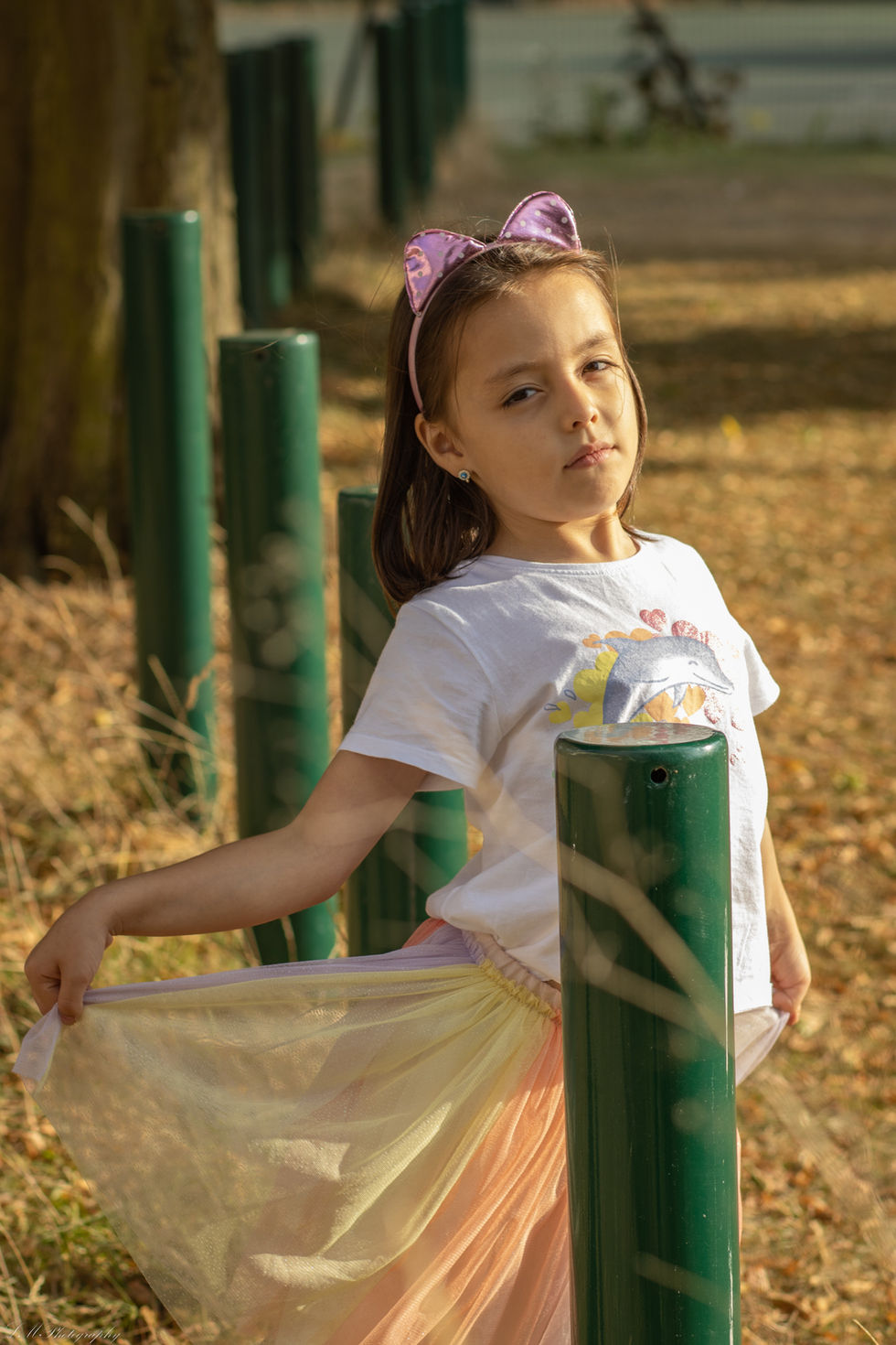 a little girl wearing a white shirt with a dolphin on it