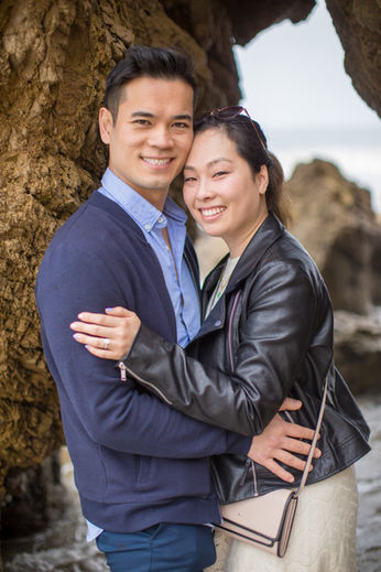 Engaged couple embracing near a large tree