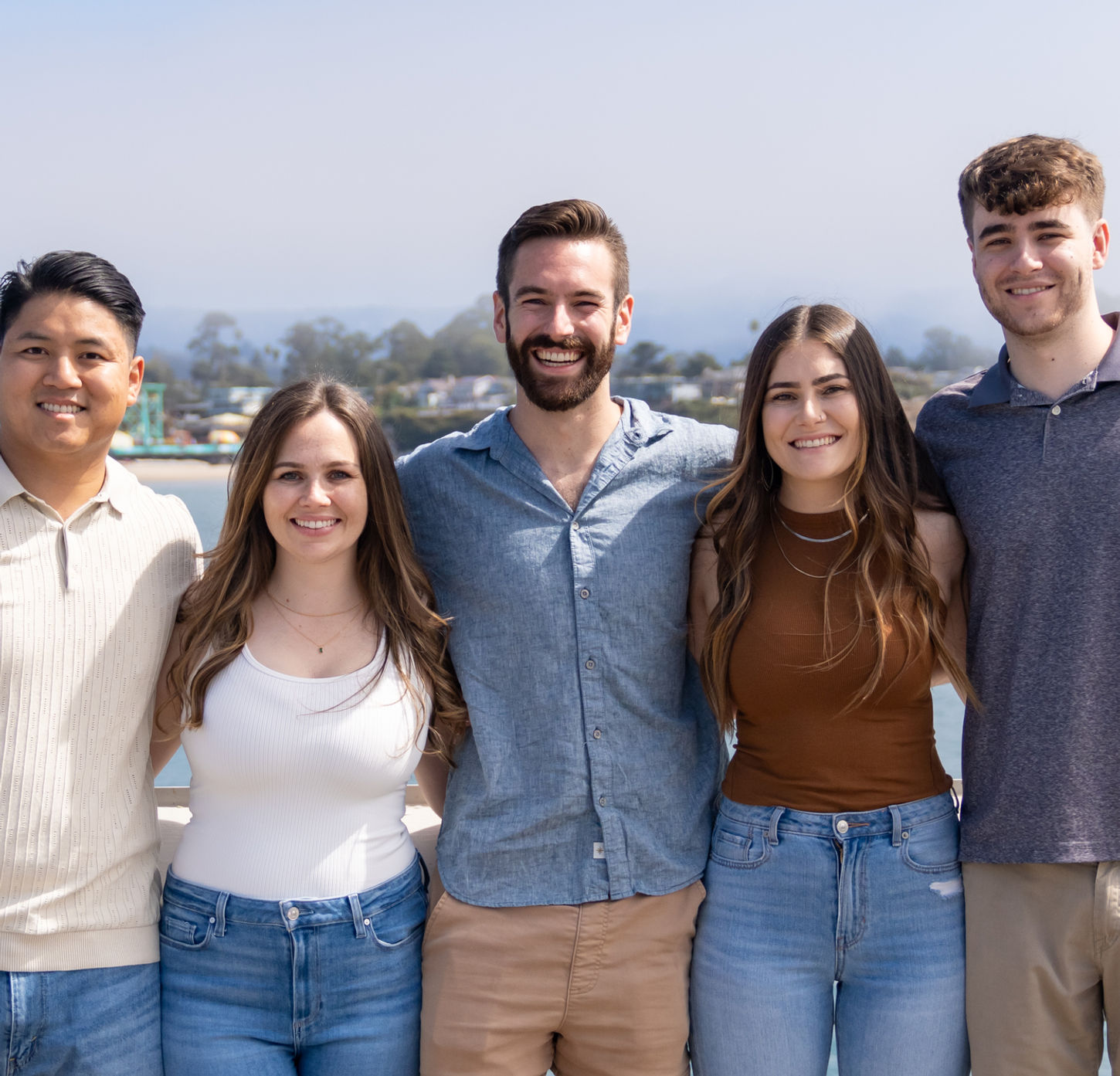 Five young adults posing together outdoors