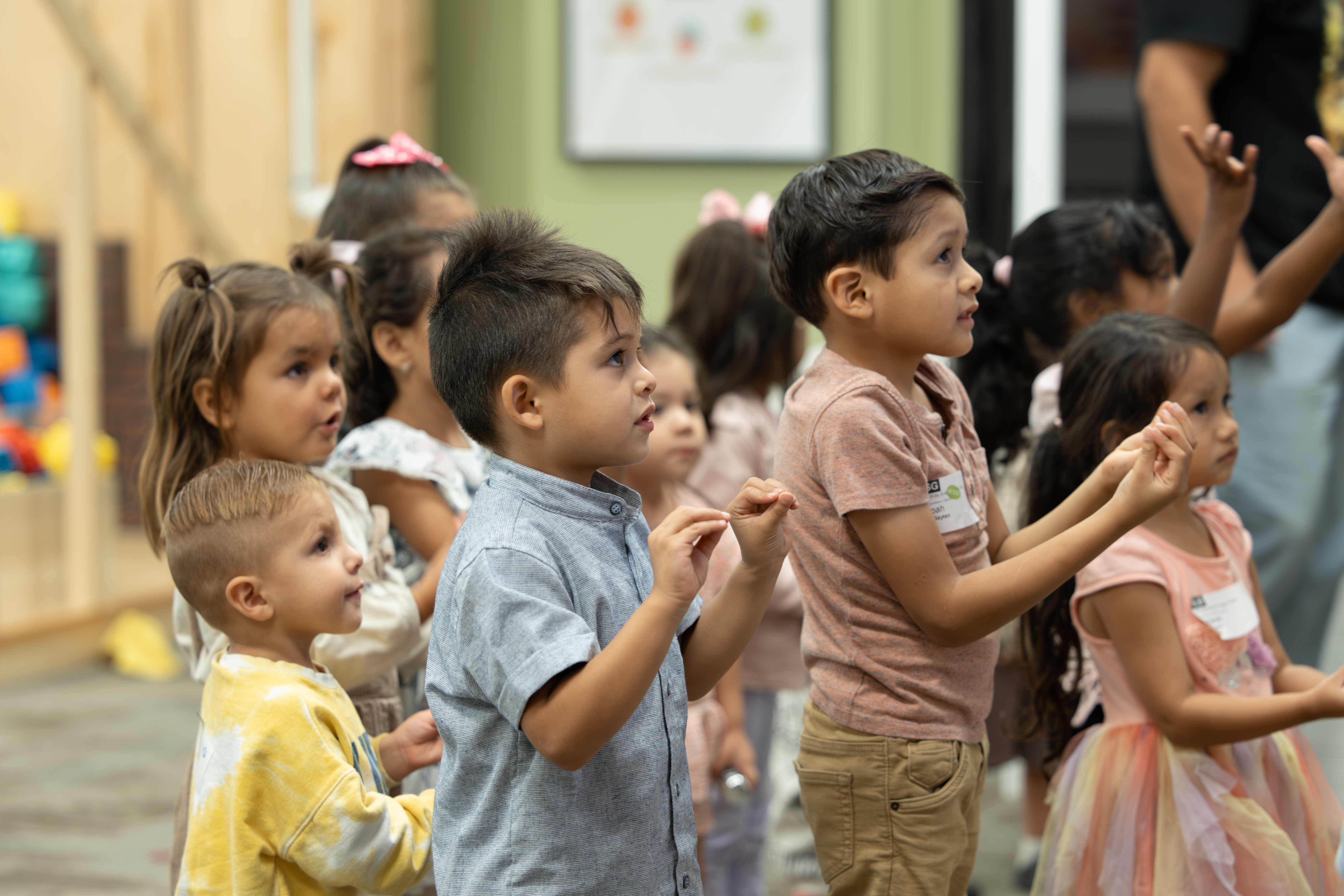 Children singing and clapping in their kids class praising God.