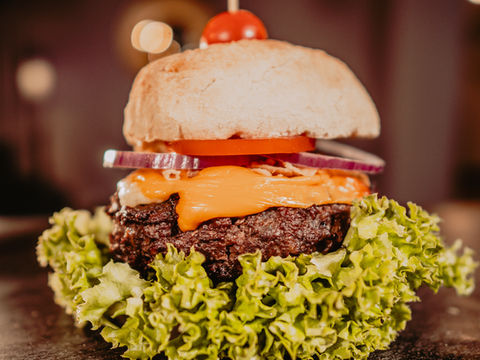 Leckerer Burger mit Käse, Salat und Tomate
