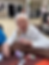 An older guest smiles while holding playing cards at a casino gathering.