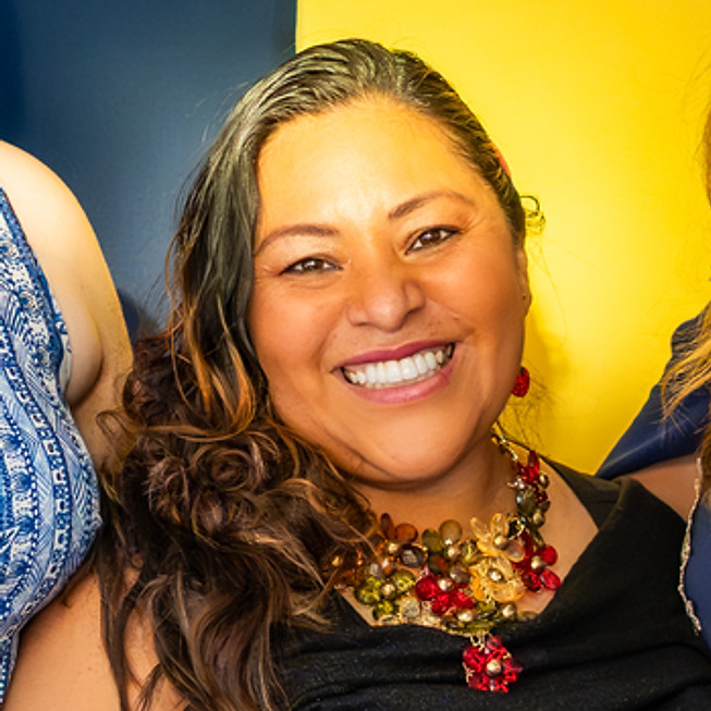 Four smiling women at an About Us event with Make Art backdrop