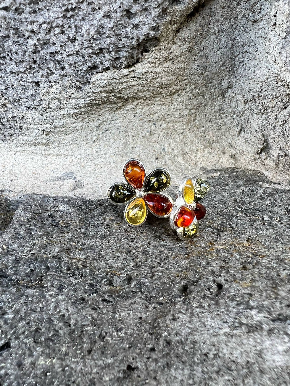 Thumbnail: Silver ring with amber stones, set against a stone background.