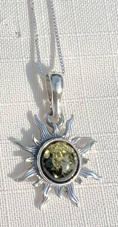 Thumbnail: Silver sun pendant necklace with green center stone on white surface