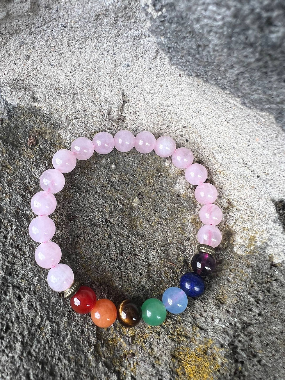 Thumbnail: Pink beaded bracelet with chakra color beads on a textured stone surface.